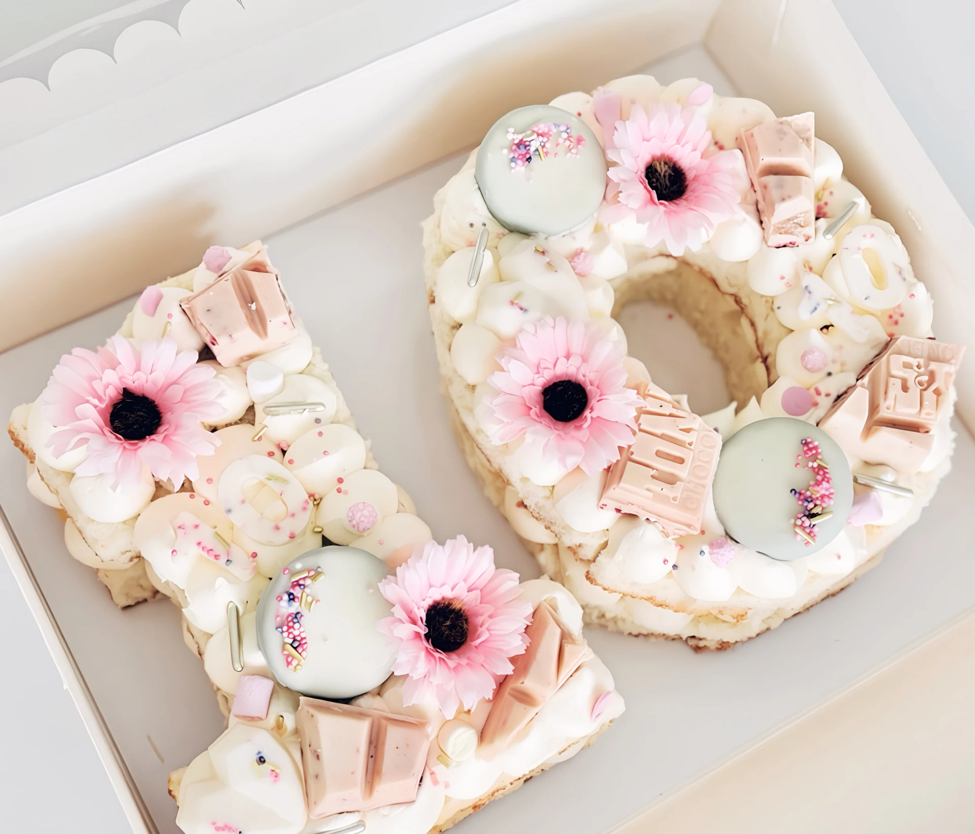 Cijfertaart met roze bloemen en zoete decoraties