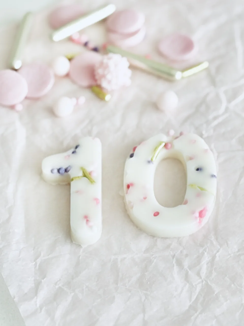 Witte chocoladecijfers 10 met roze, paarse en gouden decoraties