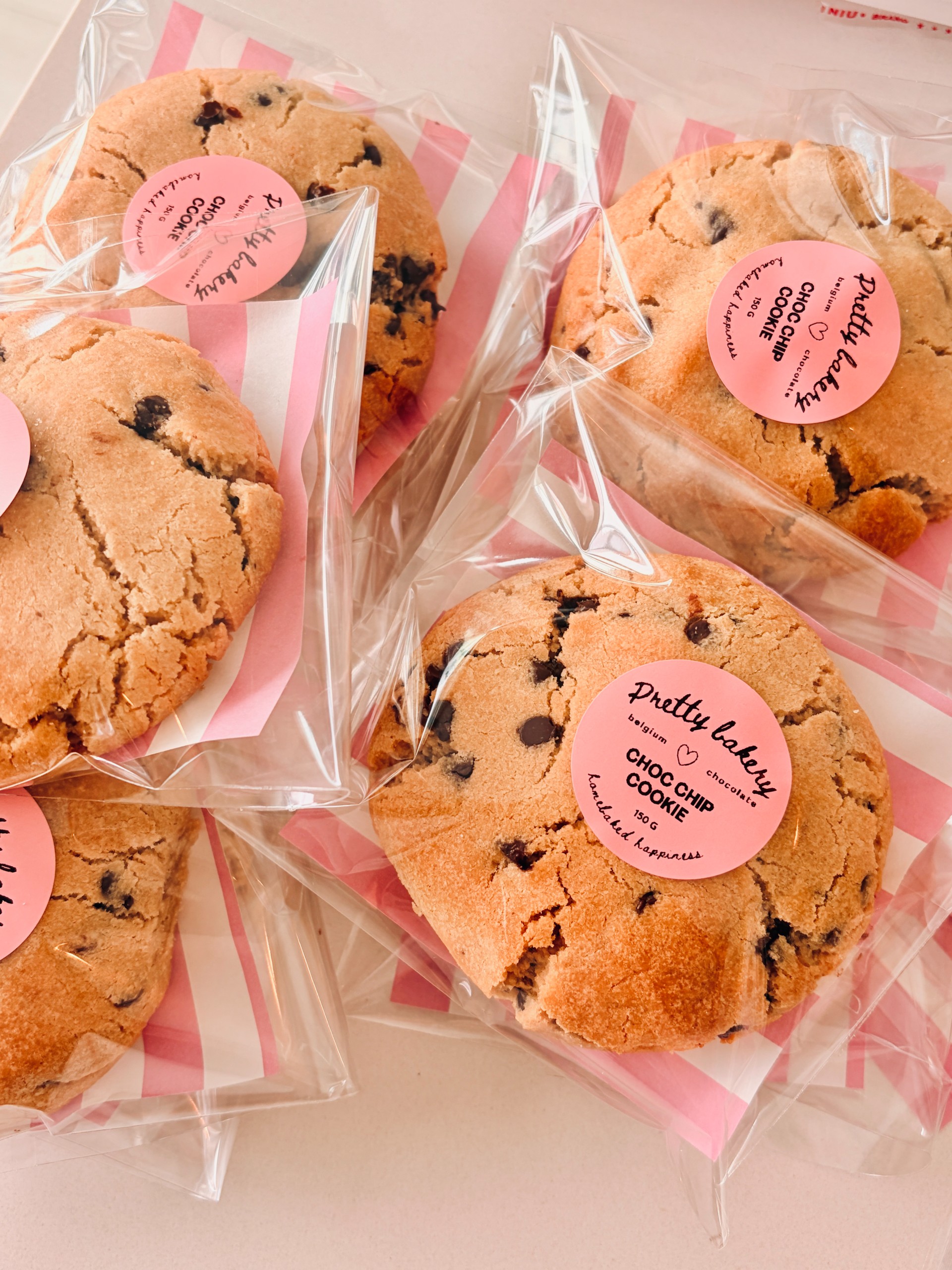 Twee boterkoekjes met roze, paarse en gouden sprinkles